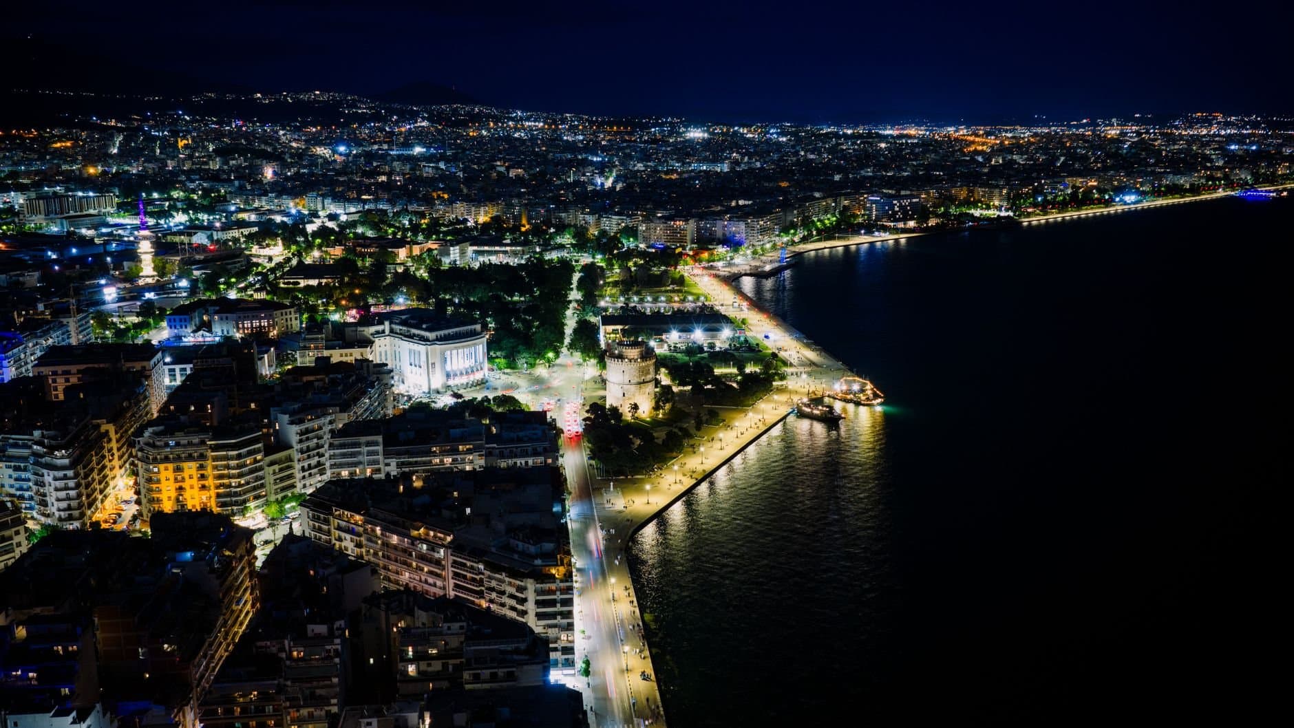 Stunning aerial night view of Thessaloniki's illuminated waterfront in Greece.