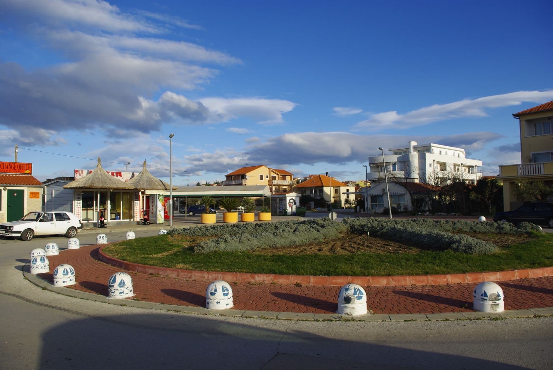 Sunny day at the town center in Pakoštane, Croatia, featuring local stores and architecture.